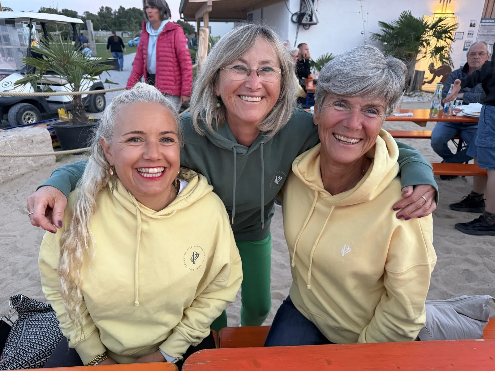 Drei Frauen der P7 Community in gelben und grünen P7-Hoodies